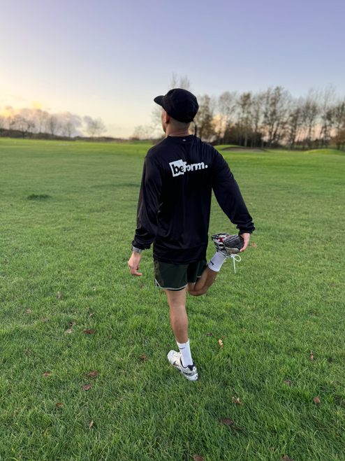 male runner stretching his quadriceps wearing a beform nutrition top