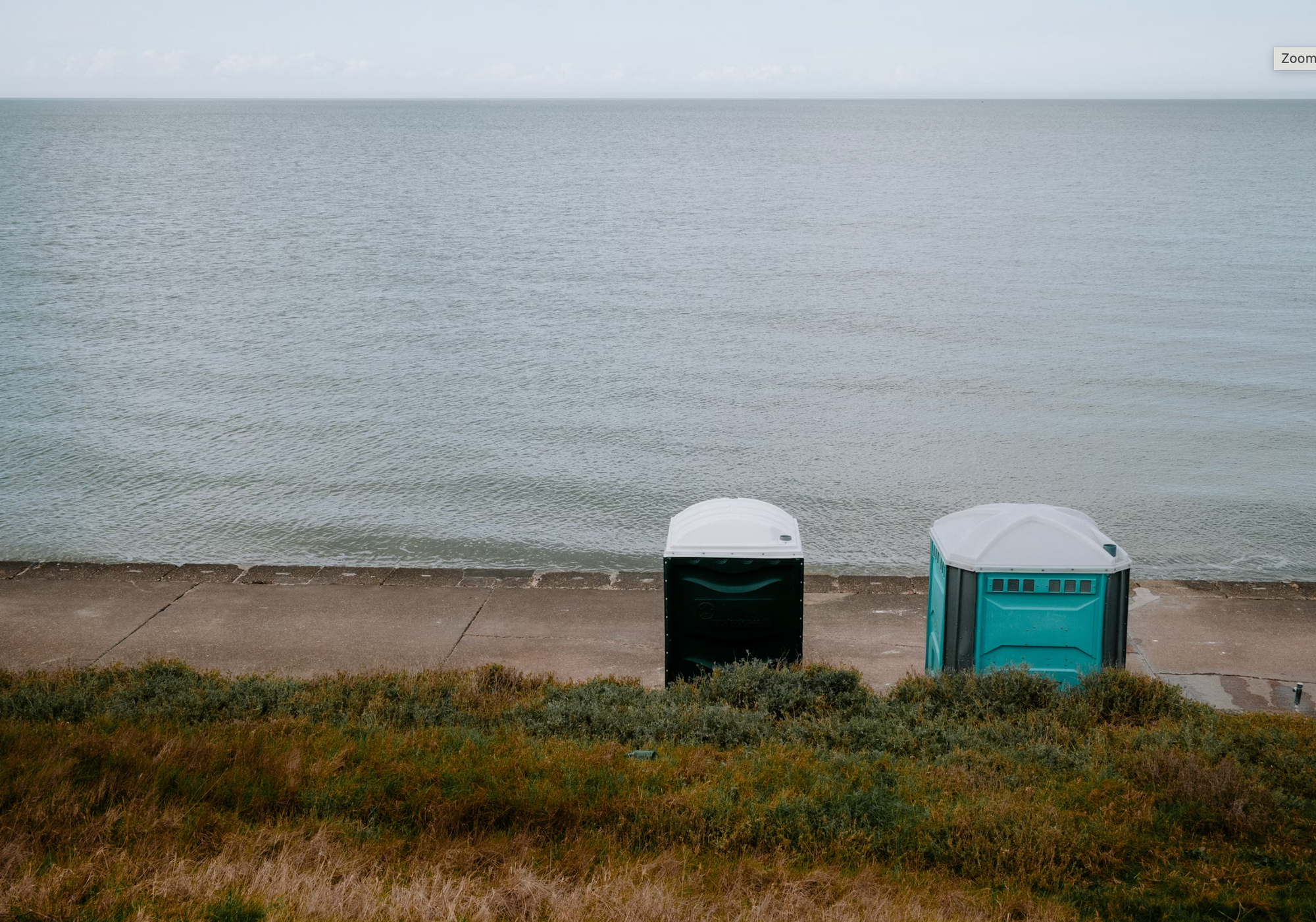2 portaloos on a beach front