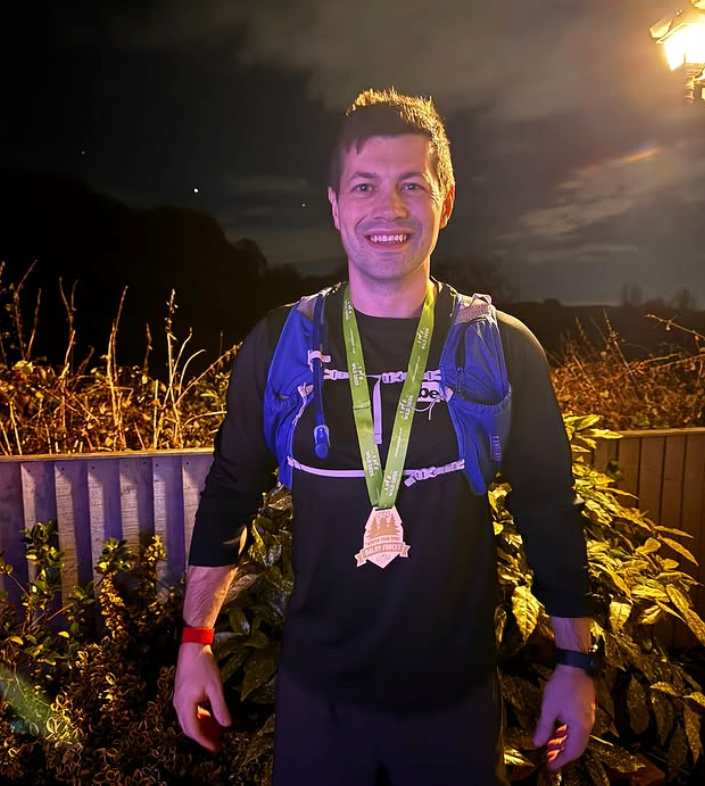 Ben bunting wearing a medal and hydration vest