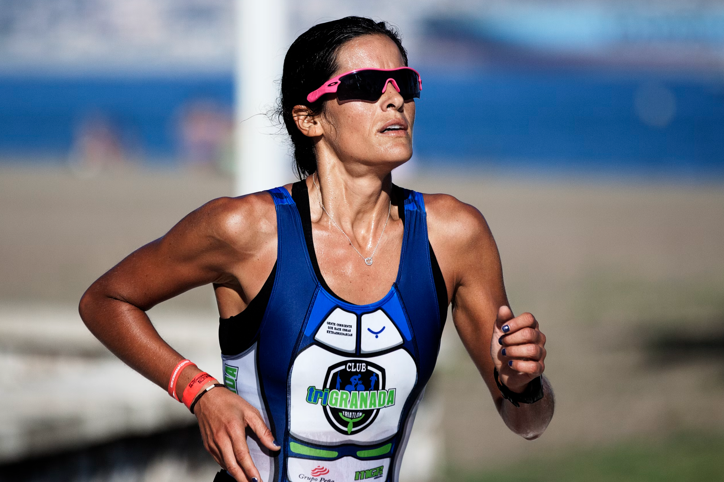 Woman running outdoors wearing a blue athletic outfit with visible branding.