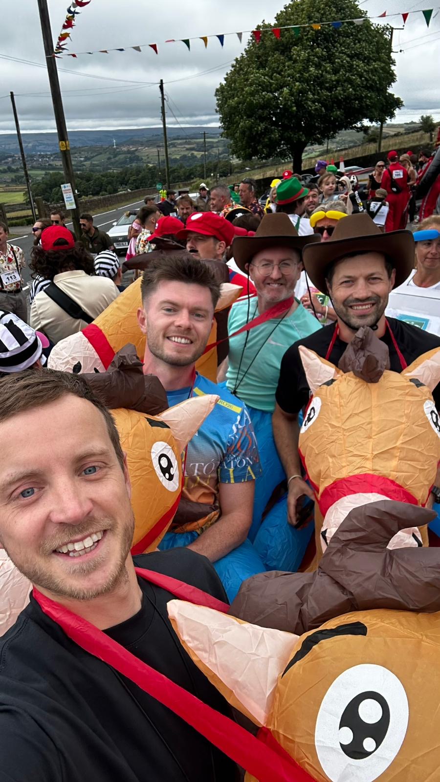 4 men wearing inflatable horse costumes