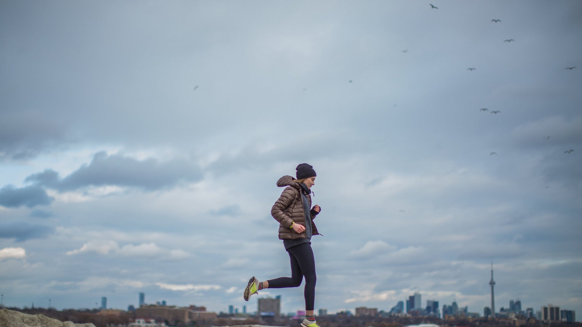 person running wearing jacket and hat 