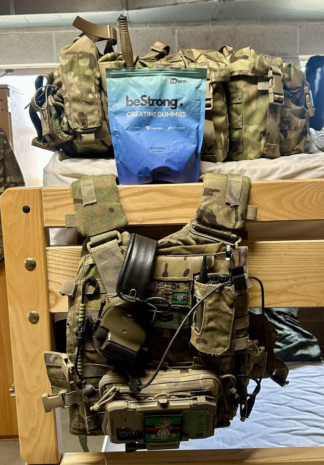 packet of beStrong creatine gummies on a bed with military webbing and belt