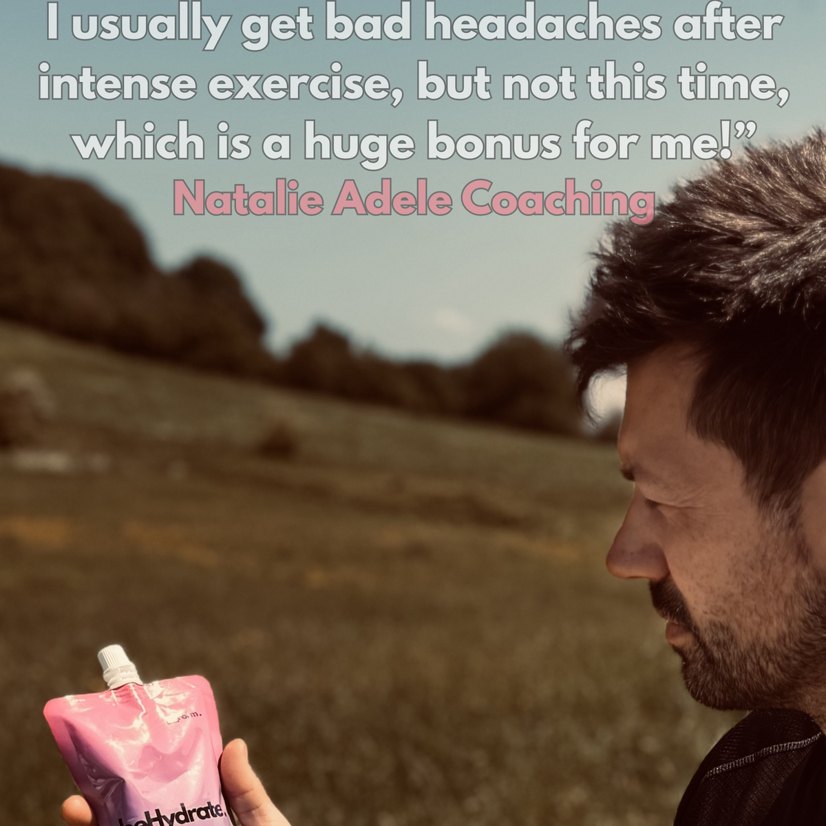 Person holding a pink and blue Hyrox hydration pouch in a natural setting with text about hydration benefits.