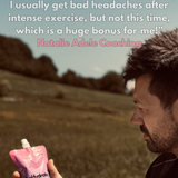 Person holding a pink and blue Hyrox hydration pouch in a natural setting with text about hydration benefits.