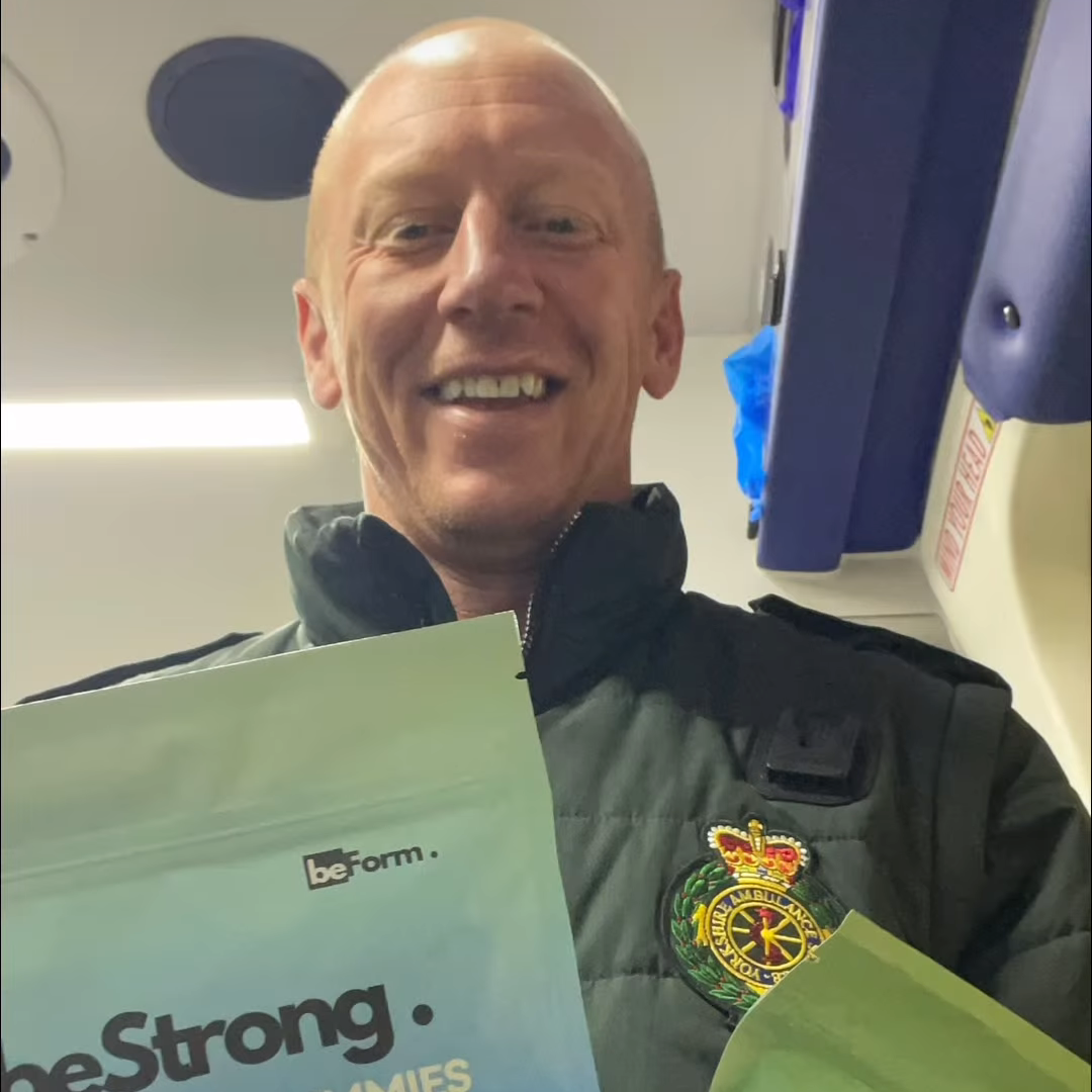 Man holding 'beStrong' and 'beFit' products with visible branding on a smartphone screen.