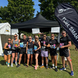 Group of people holding beForm Nutrition products in front of a tent with a visible brand logo.