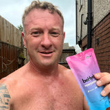 Man holding a beHydrate performance hydration pack outdoors.