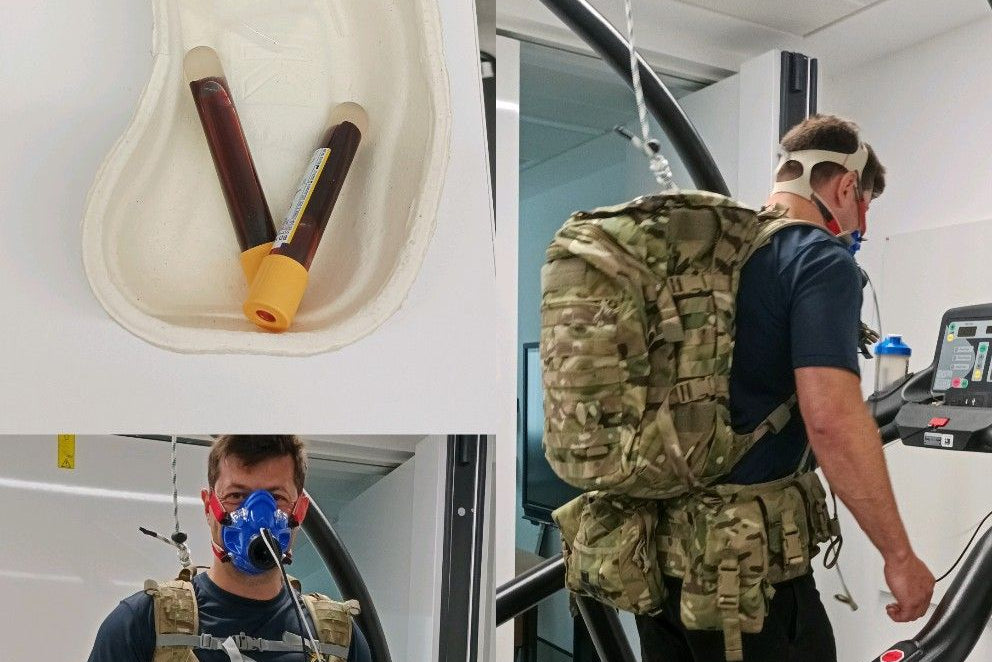 Person wearing a gas mask and backpack in a laboratory setting for vo2 max testing with blood samples in tubes.