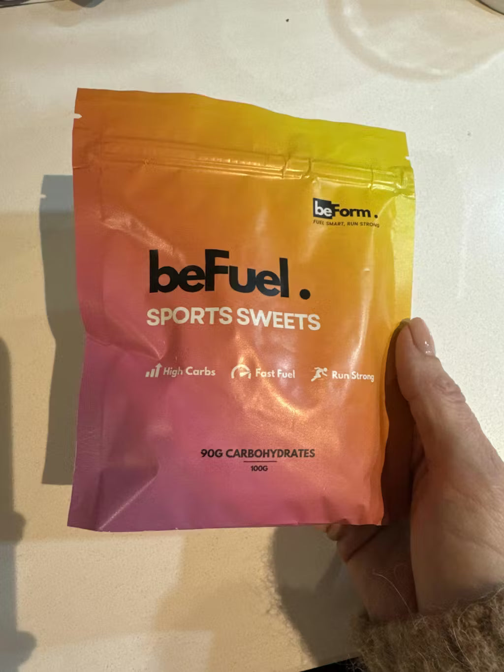 BeFuel Sports Sweets package held by a hand on a light background