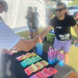 Man in black t-shirt with race number 4020 shaking hands with another person at an outdoor event.