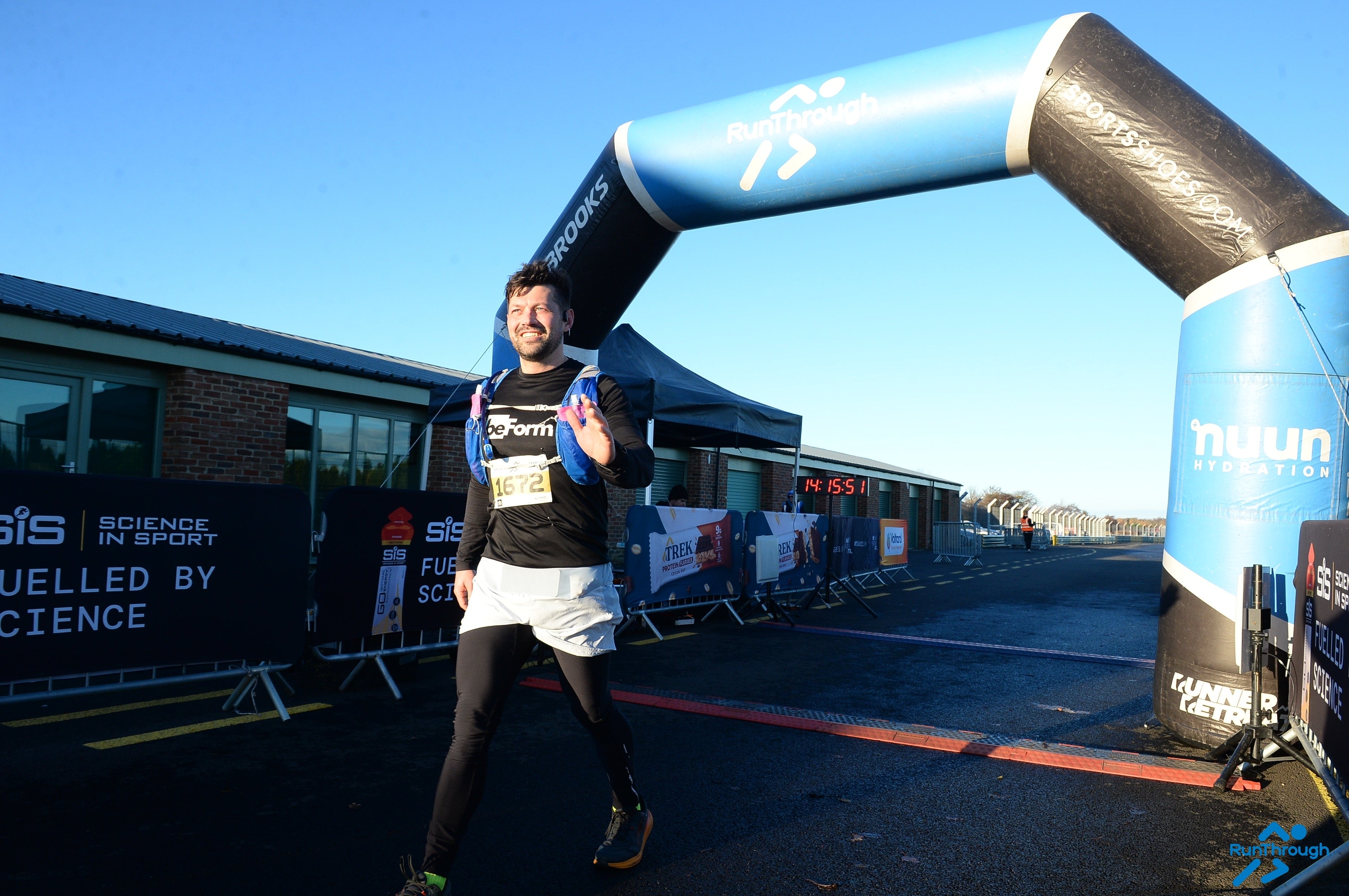 Runner crossing a finish line with event branding in the background