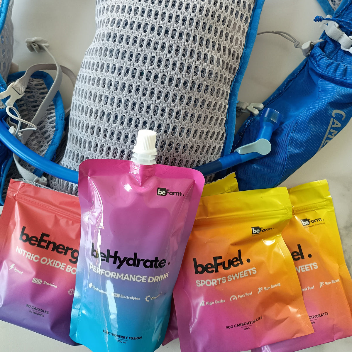 Hydration vest with behydrate sports drinks pouch and packets of befuel and beenergy on a white background