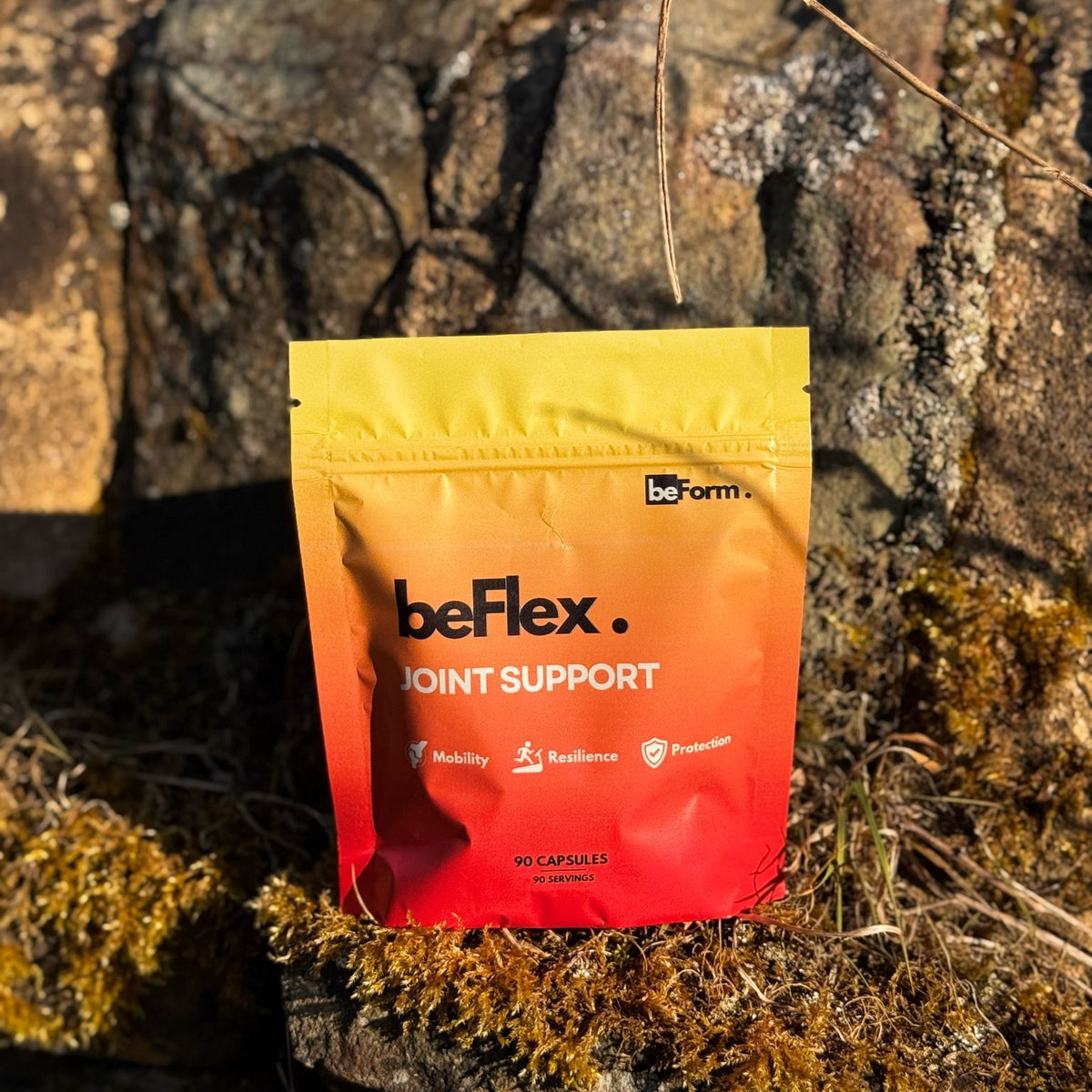 A pouch of beFlex Joint Support supplement placed on a rock surface with moss.