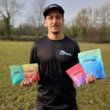 Man holding various 'beForm' supplement packets in an outdoor setting
