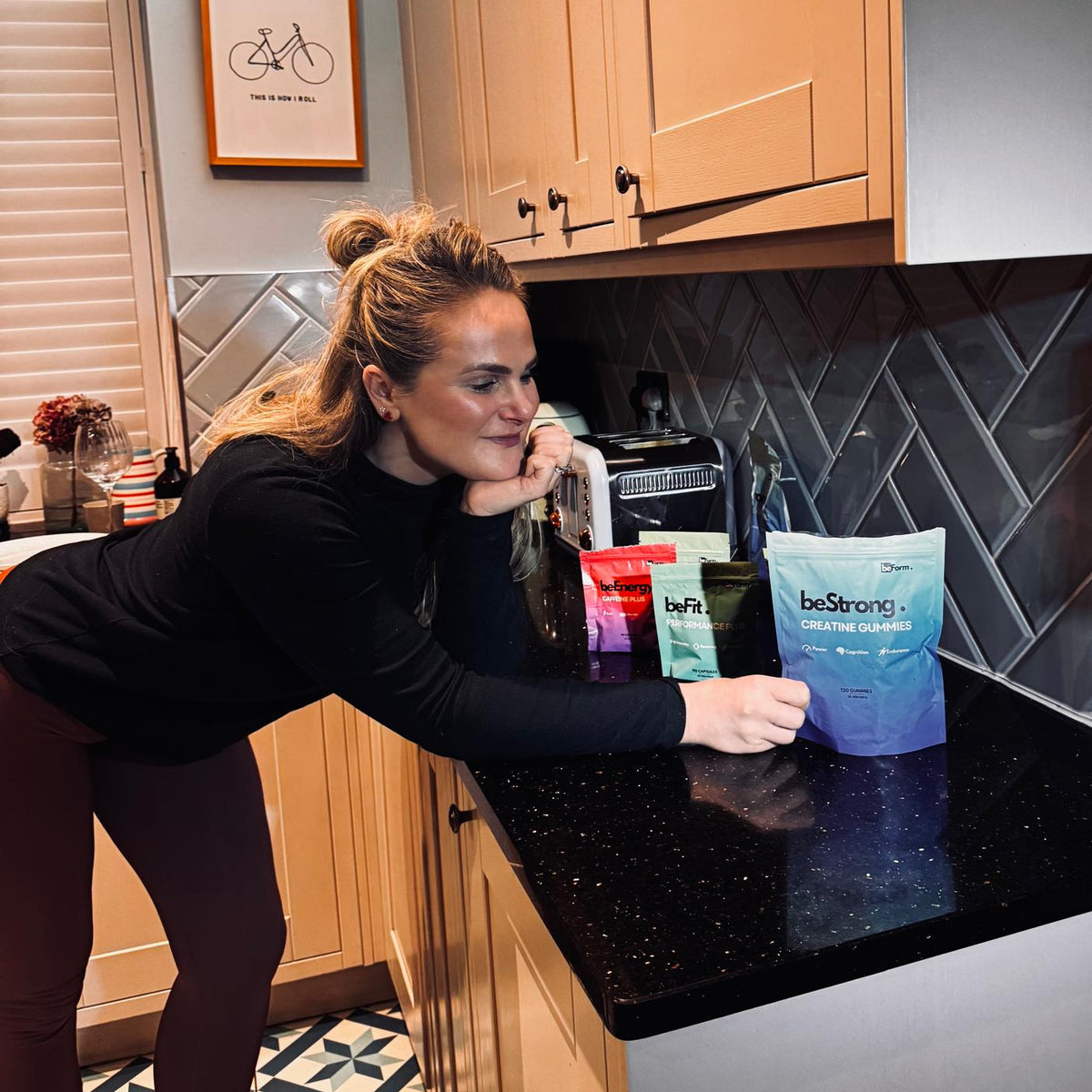 Woman in a kitchen with beStrong supplement bags on the counter