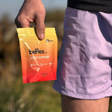 Person holding a BeFlex joint support packet outdoors.