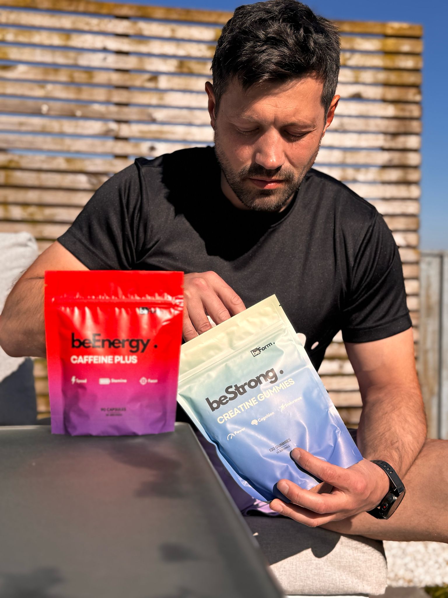 Man holding be energy and be strong supplement packages outdoors
