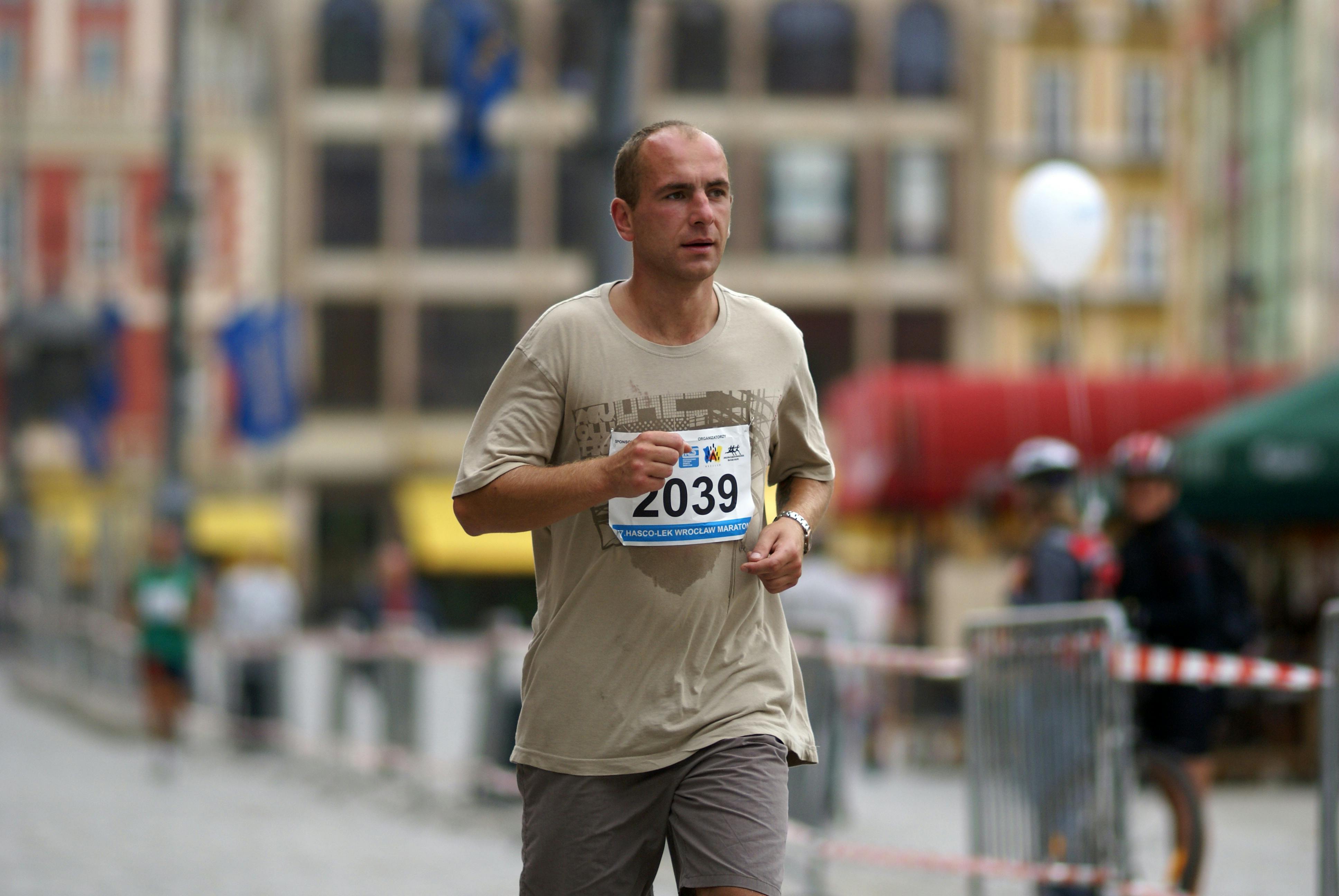 Man running in a race with a blurred urban background
