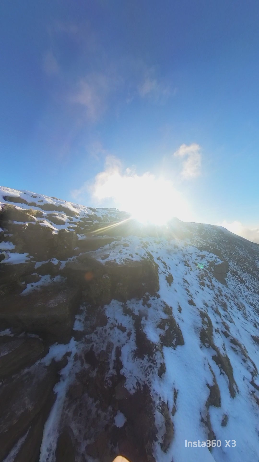 man summiting a mountain with snow